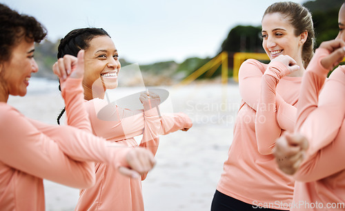 Image of Women, volleyball and team stretching on beach excited to play match, competition and sports games. Teamwork, fitness and happy female players stretch arms for warm up, training and exercise on sand