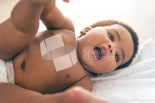 Image of Kids, black baby and a girl lying on a towel in her home for growth or child development from above. Children, bedroom and cute with a newborn infant female resting on a bed to relax in a house