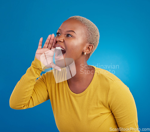 Image of Shouting, announcement and loud with a black woman on a blue background in studio for news or communication. Hand, screaming and message with an attractive young female yelling to alert danger