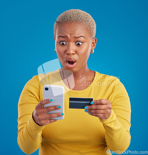 Image of Credit card, phone and woman shocked for online shopping mistake, transaction fail or debt isolated on blue background. Wow, surprise and stress person for fintech payment mistake on mobile in studio