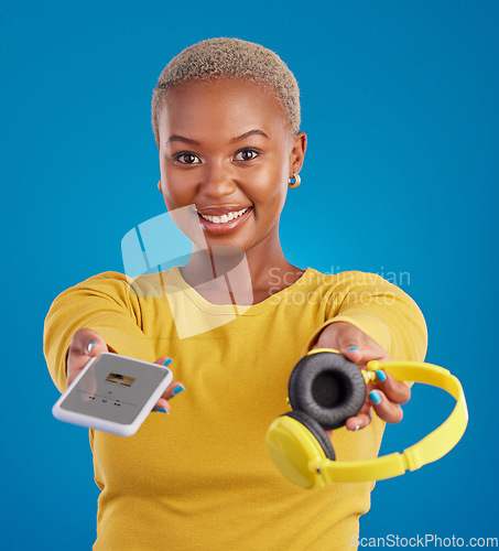 Image of Music, sharing and phone with portrait of black woman in studio for streaming, giving and multimedia for you. Podcast, mobile radio and technology with female on blue background for headphones audio