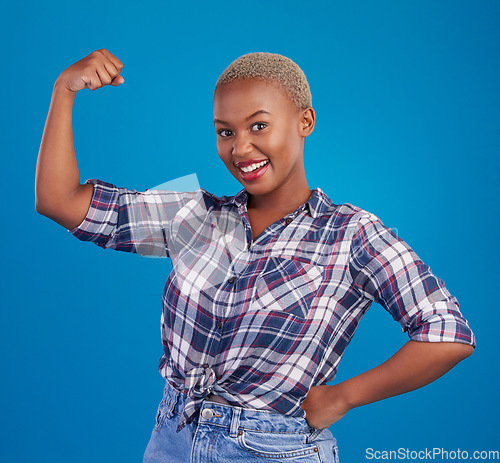 Image of Muscle, arm flex and portrait of black woman in studio for empowerment, confident and success. Achievement, hard work and pride with female isolated on blue background for power, strong or motivation