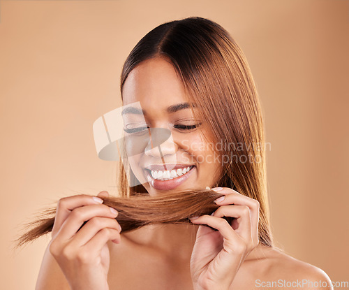 Image of Woman, beauty and hair care with a smile for growth, texture and shine shampoo on a brown background. Aesthetic female happy in studio for natural keratin treatment and wellness with color protect