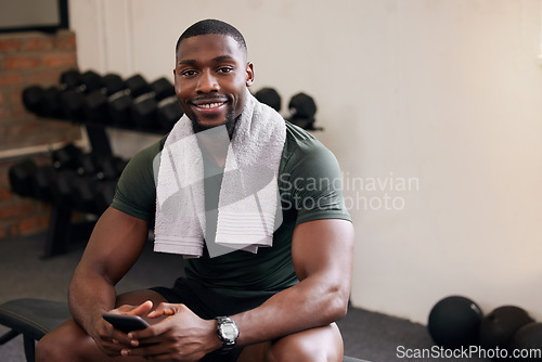 Image of Gym, phone and portrait of happy man rest to check social media, search internet and workout progress app. Black male, sports break and mobile technology for fitness, smile and bodybuilder training