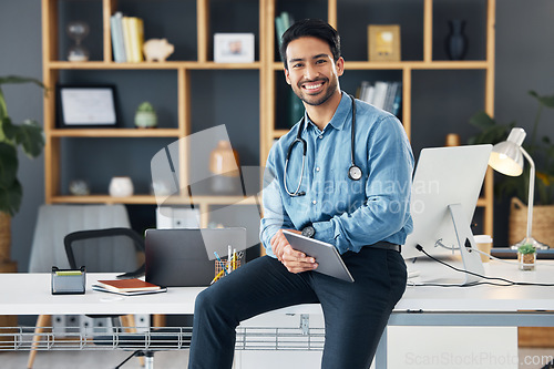 Image of Relax, tablet and portrait of healthcare professional holding device for internet, web and online connection in a office. Medical, smile and happy man doctor sitting on table or desk is satisfied