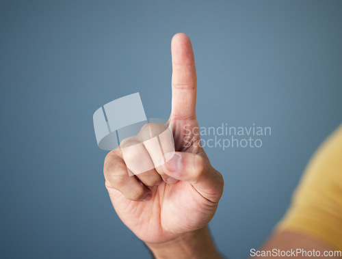 Image of Man, hand and pointing up in studio with mockup for question, choice or vote on blue background. Product placement, finger showing deal announcement or information with mock up space for notification