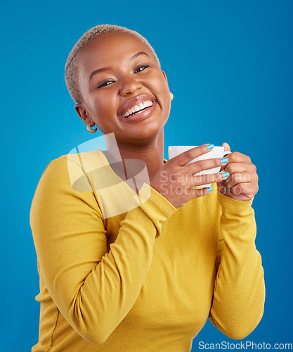 Image of Black woman, happy and coffee or tea portrait in studio with a smile and happiness. African female model with a drink and hands on cup to relax with a positive mindset on blue background with beauty