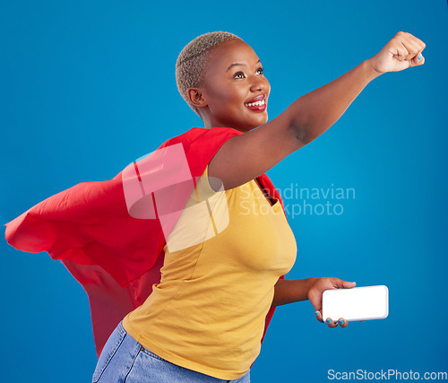 Image of Superhero, mockup and phone with black woman in studio for flying, power and deal. Mobile, strong and communication with female in red cape costume on blue background for technology, digital and 5g
