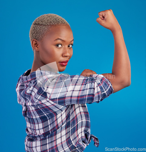 Image of Portrait, black woman and flex arms on blue background, studio and backdrop of freedom, empowerment or pride. Female model, bicep and girl power in fight of gender equality, strong muscle or feminism