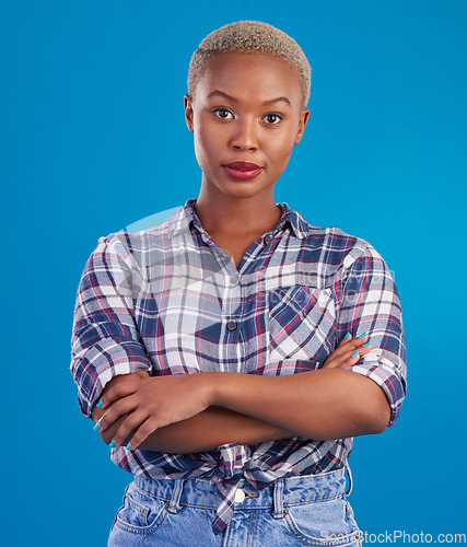 Image of Serious, confidence and portrait of black woman with crossed arms, proud and empowerment in studio. Fashion, beauty and attractive girl on blue background with pride, success mindset and motivation