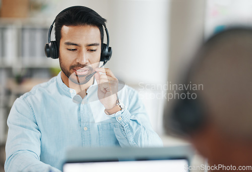 Image of Call center, consultant and man and coworking office for global discussion, tech support or ecommerce website service. Asian person or agent speaking in telemarketing, telecom or virtual salesman job