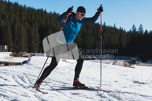 Image of Nordic skiing or Cross-country skiing classic technique practiced by man in a beautiful panoramic trail at morning.