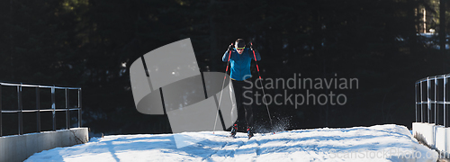 Image of Nordic skiing or Cross-country skiing classic technique practiced by man in a beautiful panoramic trail at morning.