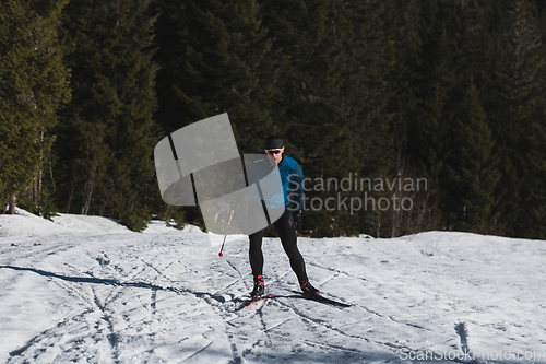 Image of Nordic skiing or Cross-country skiing classic technique practiced by man in a beautiful panoramic trail at morning.