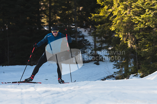 Image of Nordic skiing or Cross-country skiing classic technique practiced by man in a beautiful panoramic trail at morning.