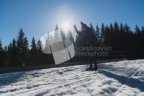 Image of Nordic skiing or Cross-country skiing classic technique practiced by man in a beautiful panoramic trail at morning.