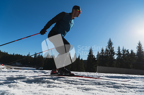 Image of Nordic skiing or Cross-country skiing classic technique practiced by man in a beautiful panoramic trail at morning.