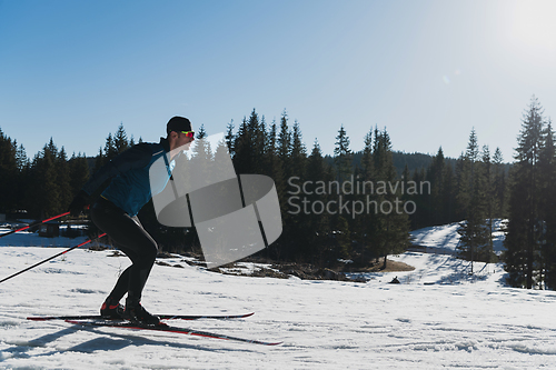 Image of Nordic skiing or Cross-country skiing classic technique practiced by man in a beautiful panoramic trail at morning.