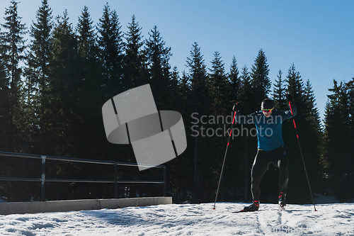 Image of Nordic skiing or Cross-country skiing classic technique practiced by man in a beautiful panoramic trail at morning.