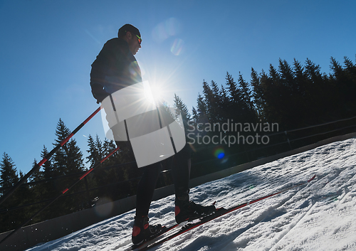 Image of Nordic skiing or Cross-country skiing classic technique practiced by man in a beautiful panoramic trail at morning.