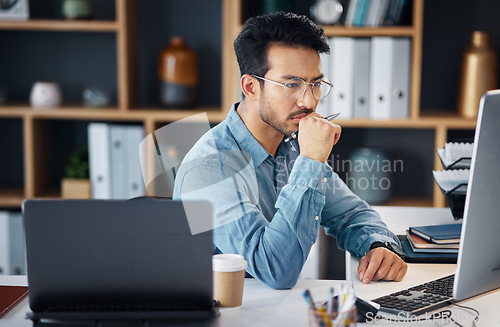 Image of Serious asian man, thinking and computer for digital marketing, project planning or schedule at office desk. Male creative designer in thought working on PC and laptop for market or startup strategy
