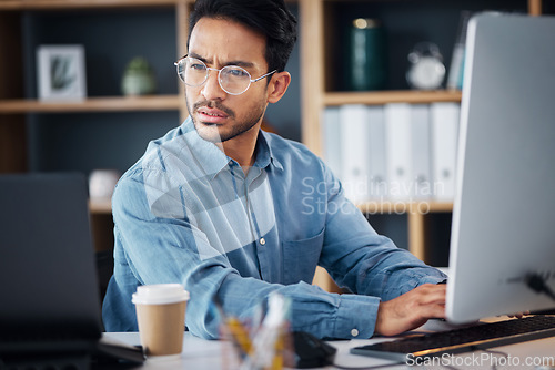 Image of Serious, business man working on computer, laptop and software development, digital research and information technology. Coding developer or asian person typing on desktop for multimedia management