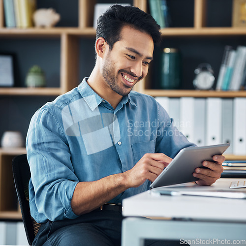 Image of Happy asian man, tablet and smile for social media, communication or networking at office desk. Male creative designer smiling on touchscreen for digital marketing, browsing or advertising in startup