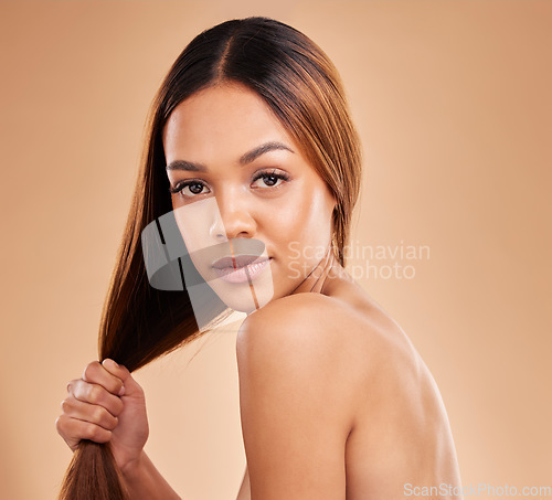 Image of Woman, beauty and hair care portrait for growth and shine shampoo on a brown background. Aesthetic female in studio for natural keratin treatment and skincare wellness with color and strong texture