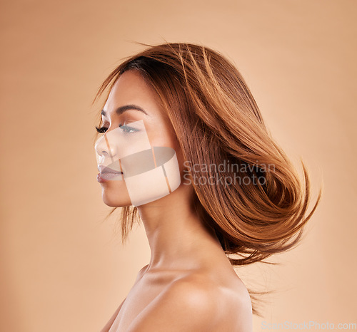 Image of Beauty, hair and salon with a model black woman in studio on a beige background for keratin treatmet. Face, haircare or shampoo and an attractive young female posing with the wind in her hairstyle