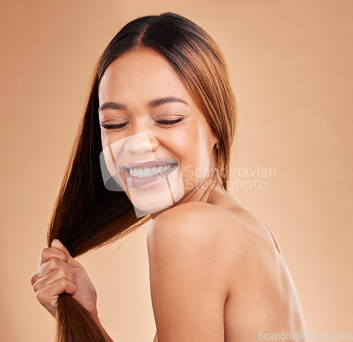 Image of Woman, beauty and hair care with a smile for growth and shine shampoo on a brown background. Aesthetic female happy in studio for natural keratin treatment and wellness with color and strong texture