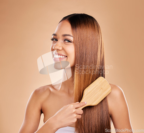 Image of Woman, beauty and brush hair portrait for growth and shine for healthy texture on a brown background. Smile of aesthetic female in studio brushing for natural keratin treatment haircare results