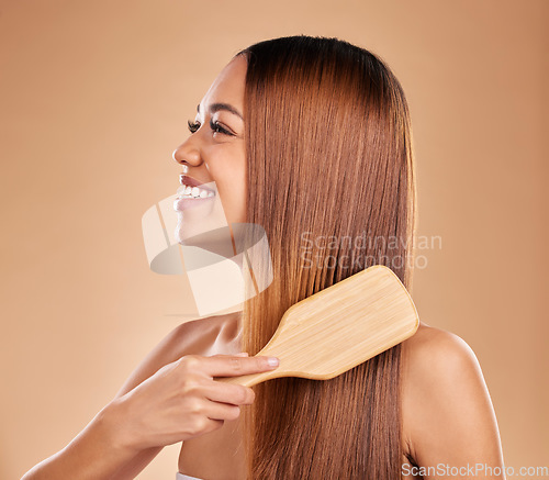 Image of Beauty, woman and brush hair for growth and shine for straight texture on a brown background. Smile of aesthetic female happy in studio brushing for natural keratin treatment haircare results