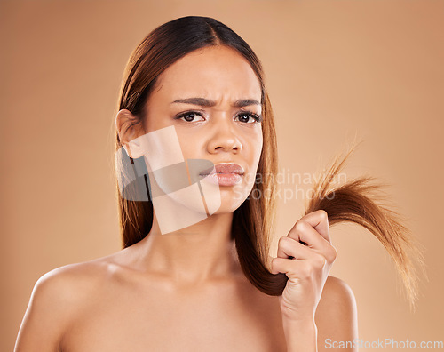 Image of Hair care, frustrated and portrait of a woman with split ends isolated on a studio background. Unhappy, frizzy and a girl with a problem with damaged, tangled and breakage of a hairstyle on backdrop