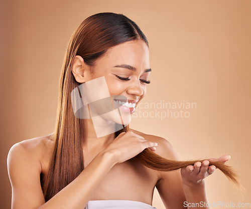 Image of Woman, beauty and happy with hair texture with growth and shine shampoo on a brown background. Smile of aesthetic female excited in studio for natural keratin treatment wellness with haircare results