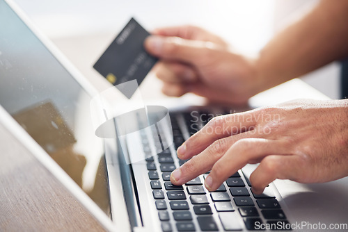 Image of Hands, laptop and credit card for ecommerce, online shopping or electronic purchase on wooden desk. Hand of shopper working on computer keyboard for internet banking, app or wireless transaction