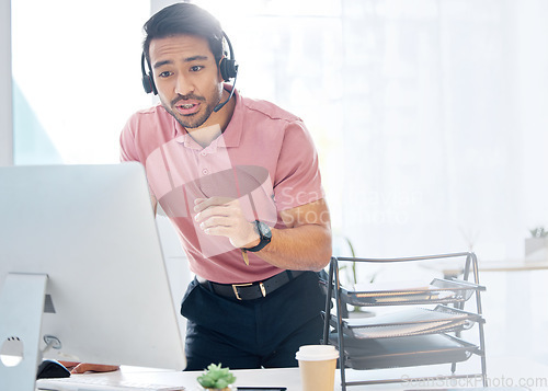 Image of Asian man, call center and consulting with headphones on computer for customer service or desktop support at office. Male consultant agent talking with headset on PC for online telemarketing advice