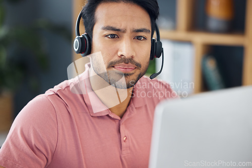 Image of Serious asian man, call center and computer with headphones for customer service, help or support at office. Focused male consultant or agent with headset on PC for telemarketing or online advice