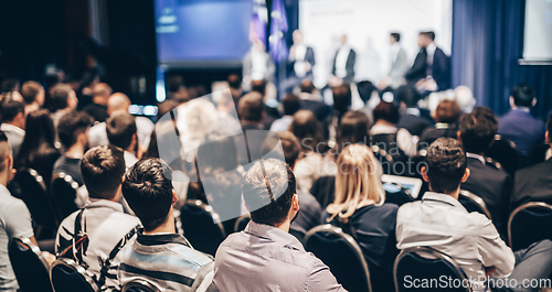 Image of Speaker giving a talk in conference hall at business event. Rear view of unrecognizable people in audience at the conference hall. Business and entrepreneurship concept.