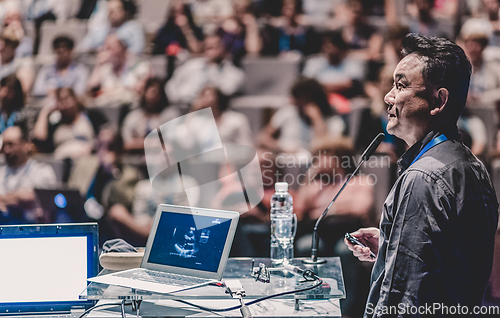 Image of Public speaker giving talk at Business Event.