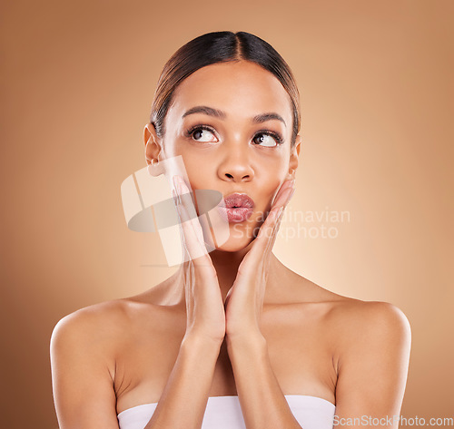 Image of Beauty, thinking and a woman with hands on face for skin care glow and shine in studio on brown background. Aesthetic female model with spa facial, dermatology cosmetic and wellness wow idea