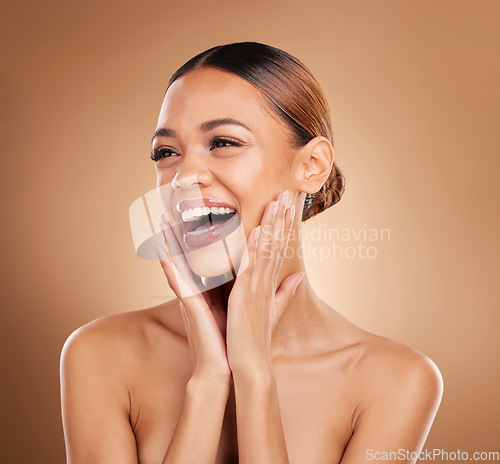 Image of Beauty, smile and a woman with hands on face for skin care glow and shine in studio on brown background. Aesthetic female model laugh and satisfied with spa facial, dermatology cosmetic and wellness
