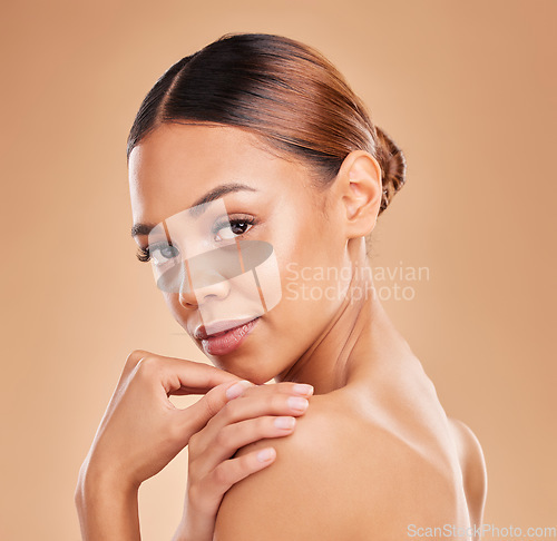 Image of Beauty, portrait and a woman with hands on skin for glow and shine in studio on brown background. Serious female model face satisfied with facial, dermatology cosmetics and wellness with skincare