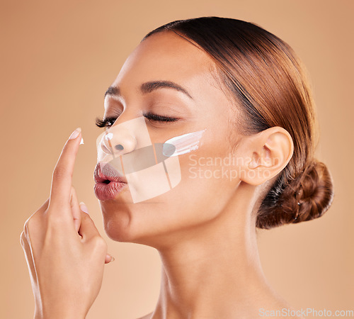 Image of Face, skincare kiss and woman with cream in studio isolated on a brown background. Dermatology, beauty cosmetics and female model with nose lotion, creme or facial moisturizer product for skin health