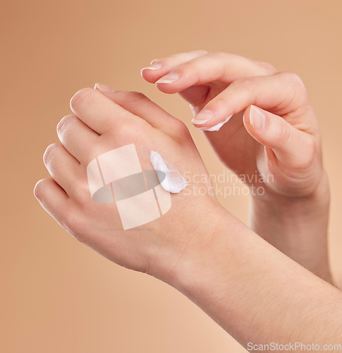 Image of Hands, skincare and beauty cream in studio isolated on a brown background. Dermatology, cosmetics and woman or female model apply lotion, creme or moisturizer product for skin health or hydration.