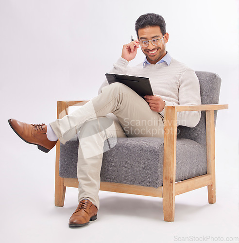 Image of Chair, clipboard and therapist man isolated on a white background reading therapy notes, checklist and review. Asian professional person or psychologist relax on armchair with career folder in studio