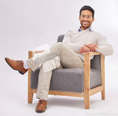 Image of Confident, chair and portrait of entrepreneur sitting happy with a smile and crossed legs isolated in studio white background. Gentleman, relax and professional or proud male employee or business man