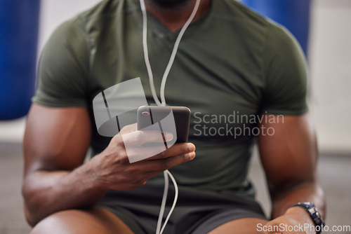 Image of Phone, music and man hands in gym for workout, search social media and online training podcast. Closeup sports person, smartphone and listening with earphones on mobile, exercise app and connection