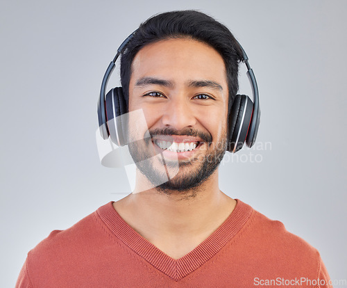 Image of Call center, portrait and man consultant in studio happy while working in crm, faq or telemarketing on grey background. Face, online, support and customer service agent consulting for virtual startup