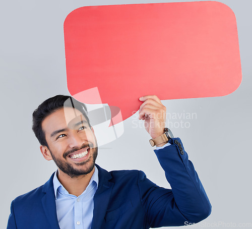 Image of Smile, speech bubble and happy businessman in studio with mockup for social media, advertising or space. Blank, poster and asian guy with billboard for news, announcement or brand on grey background