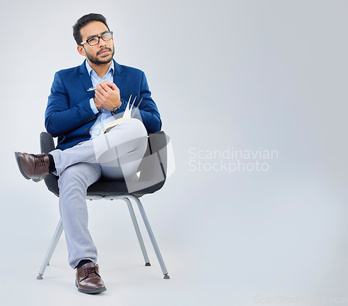 Image of Human resources, concentration and businessman with notebook for interview process in studio on grey background. Recruiter, asian male and recruitment process, negotiation and onboarding meeting